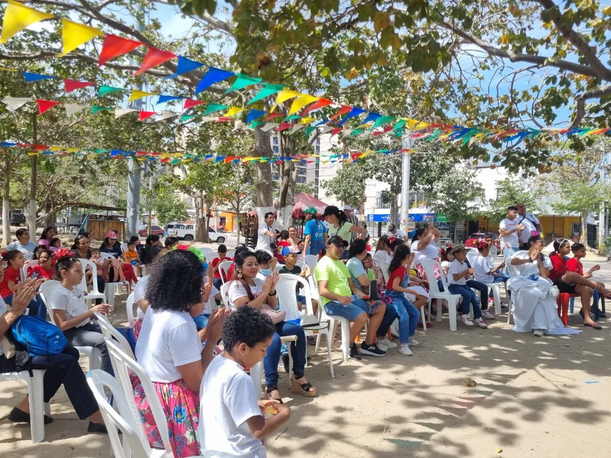 Comunidad reunida bajo banderines de colores en una jornada de Ciudad del Arte